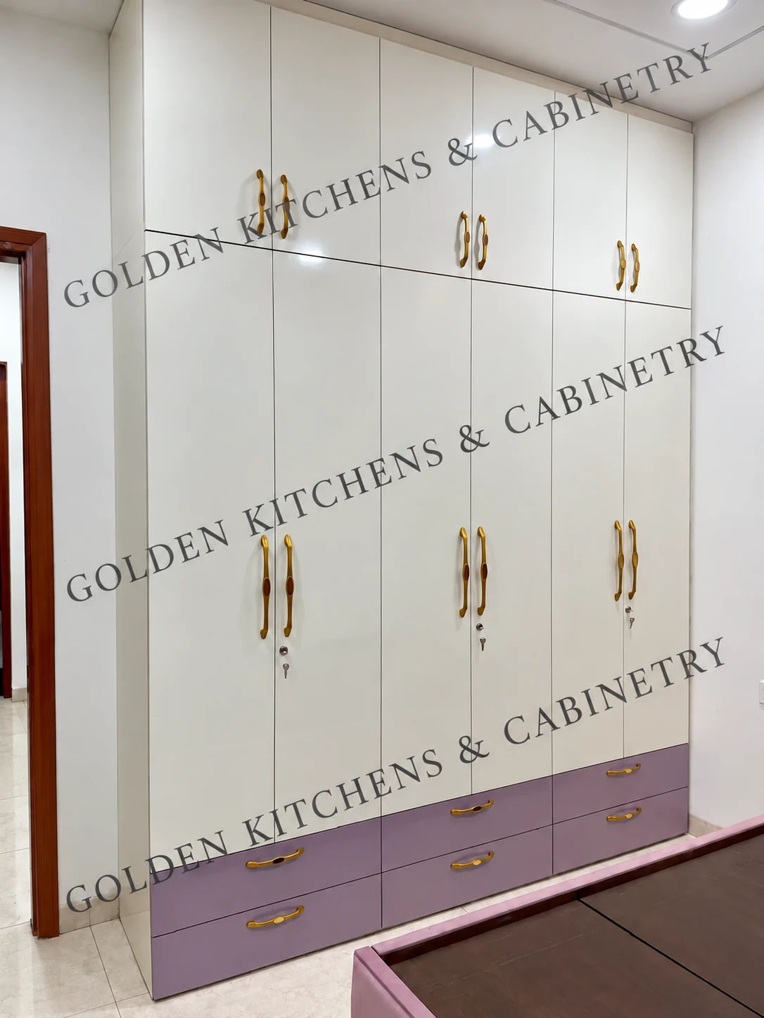 Glossy white wardrobe with brass-toned handles